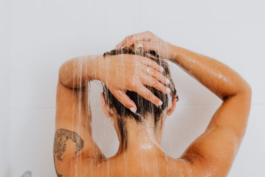 Silver-haired woman in bathroom — how to stop grey hair from turning yellow