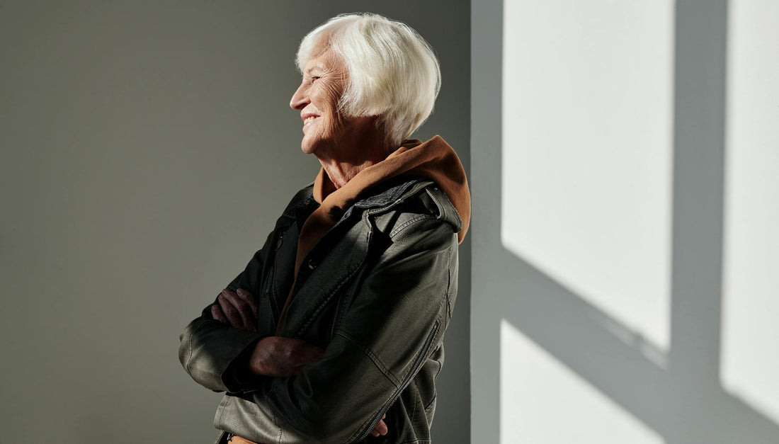 Senior woman in black leather jacket smiling confidently