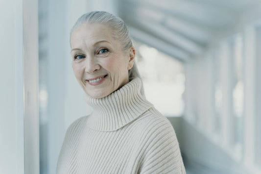 Senior woman with grey hair smiling in a serene setting