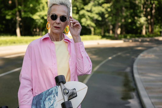 Senior woman with longboard breaking style rules in a park